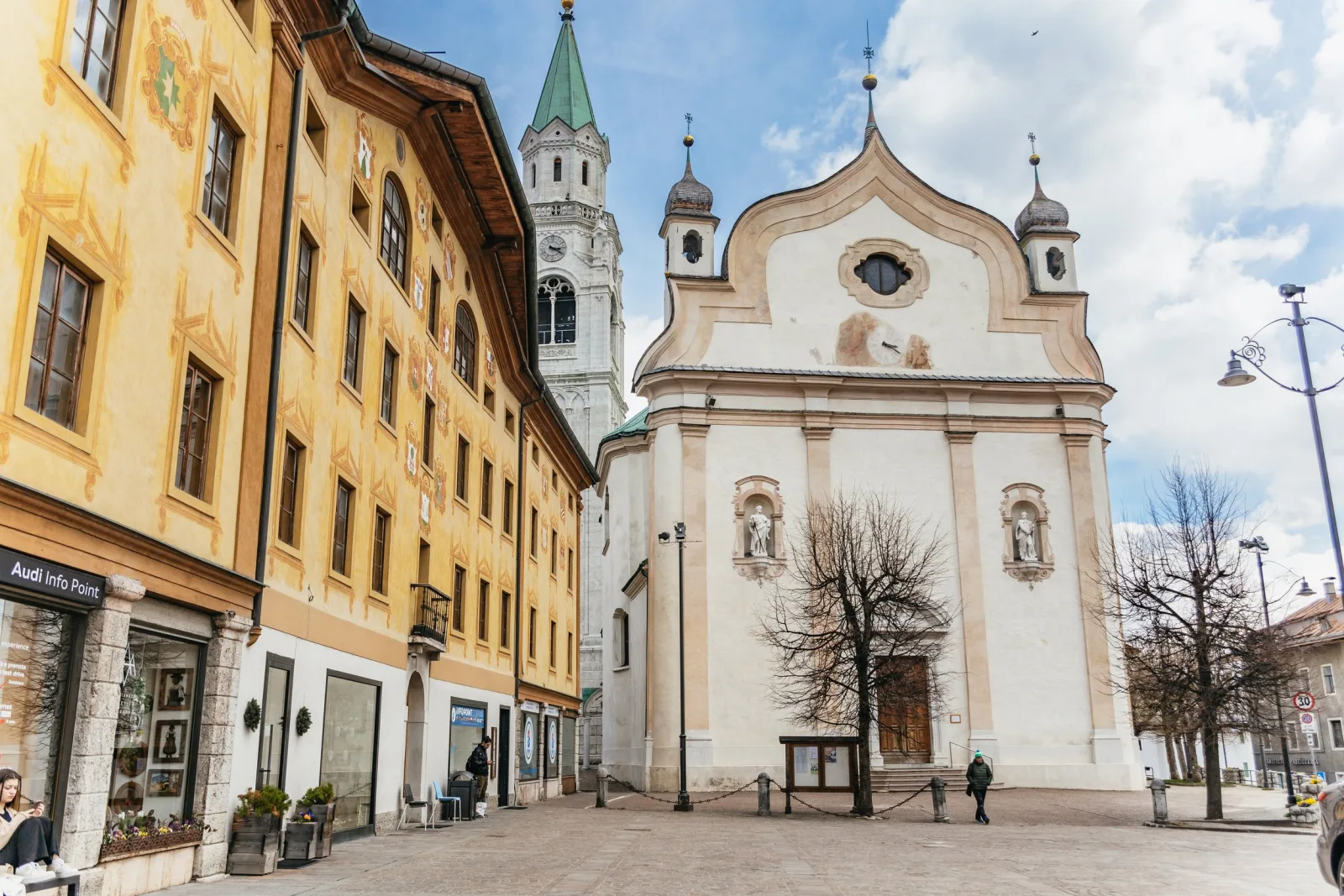 The pale baroque facade of Cortina d'Ampezzo's parish church on the Corso Italia