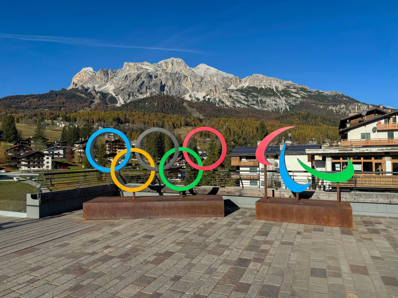 The Olympic rings monument on an empty terrace above Cortina d'Ampezzo with peaks behind