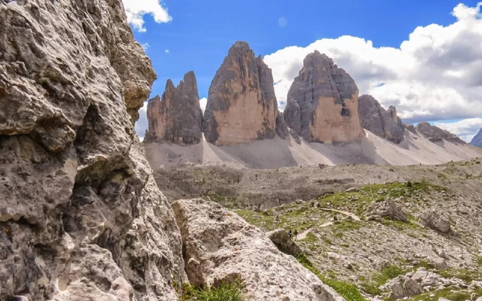The three rock towers of the Tre Cime di Lavaredo seen across scree from a rocky foreground