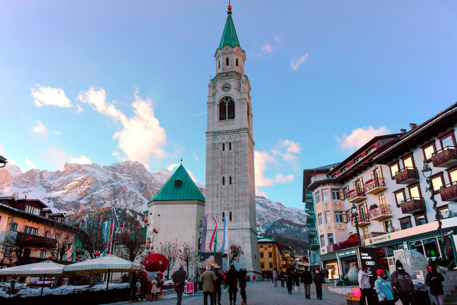 Cortina d'Ampezzo's bell tower rising over the main street with snow-covered peaks behind